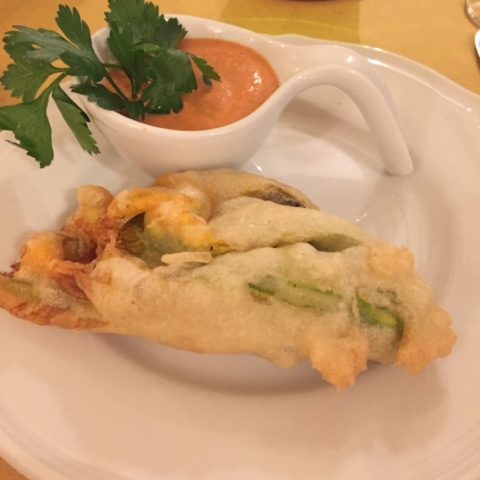 fried zucchini on a plate with sauce